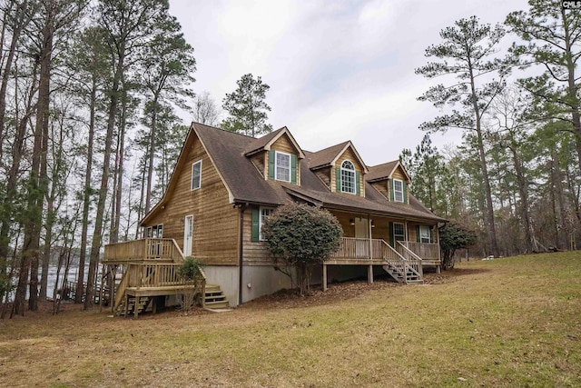 view of front of property with stairway, roof with shingles, covered porch, and a front yard