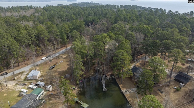 drone / aerial view with a wooded view and a water view