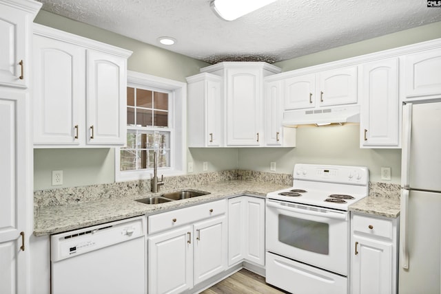 kitchen with under cabinet range hood, white appliances, white cabinets, and a sink