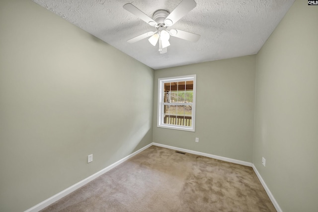 carpeted empty room with visible vents, baseboards, a textured ceiling, and a ceiling fan