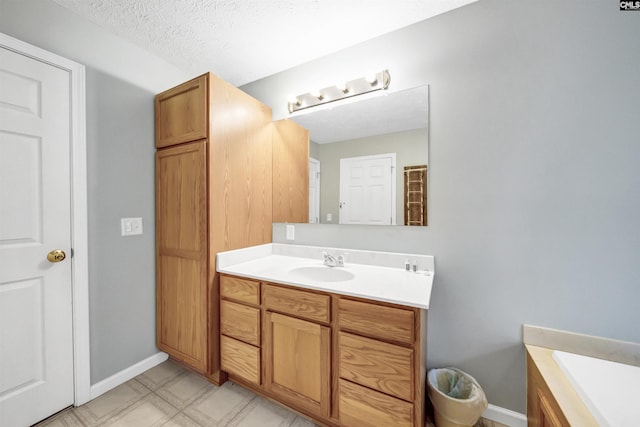 full bath with baseboards, a textured ceiling, and vanity