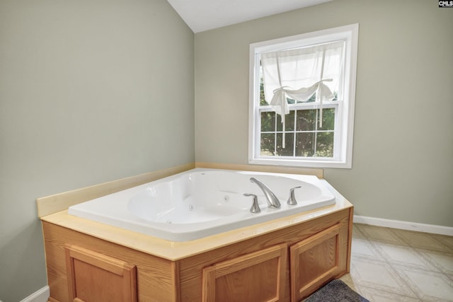 bathroom featuring a tub with jets and baseboards