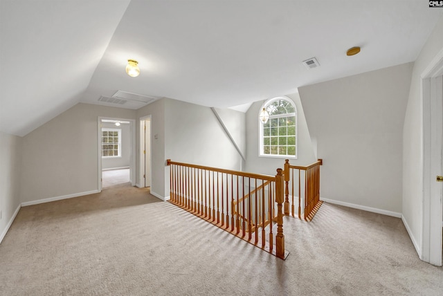 additional living space with lofted ceiling, baseboards, visible vents, and carpet floors