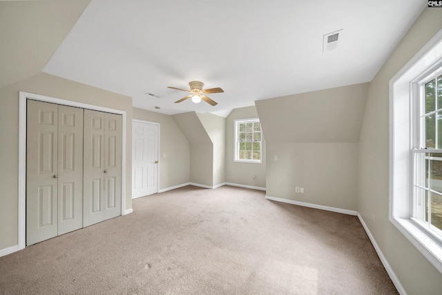 additional living space featuring visible vents, carpet, baseboards, ceiling fan, and vaulted ceiling