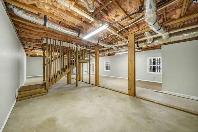 below grade area featuring stairway and baseboards