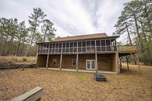 back of property featuring french doors, a fire pit, a patio area, and a sunroom