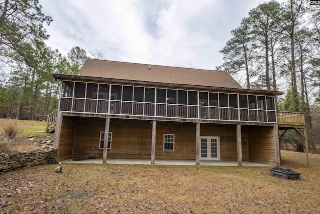 rear view of house with a patio, french doors, a sunroom, and a fire pit