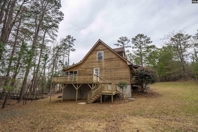 rear view of house featuring a wooden deck, stairs, and fence