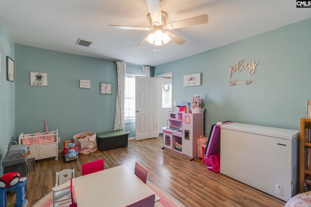 playroom featuring visible vents, wood finished floors, and ceiling fan