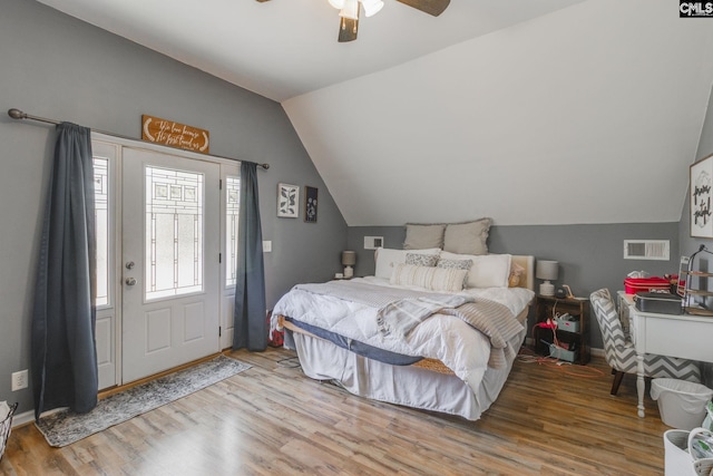 bedroom featuring a ceiling fan, vaulted ceiling, wood finished floors, and visible vents