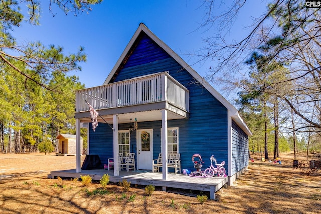 view of front of house with an outbuilding and a balcony