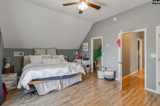 bedroom with visible vents, light wood-style flooring, a ceiling fan, baseboards, and lofted ceiling