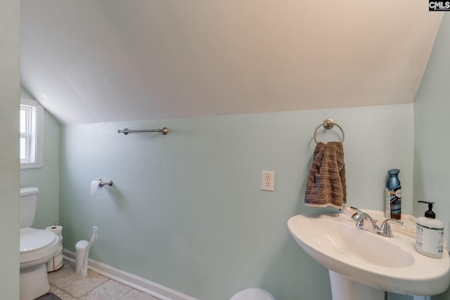 bathroom with baseboards, a sink, vaulted ceiling, tile patterned floors, and toilet