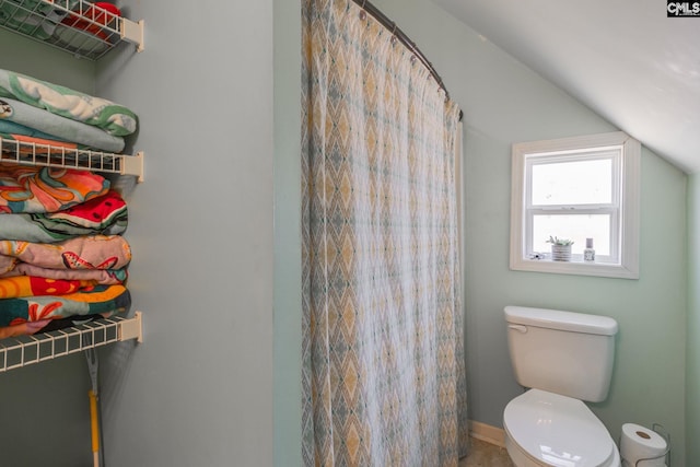 full bath with a shower with shower curtain, vaulted ceiling, and toilet