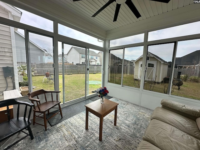 sunroom with a residential view and ceiling fan