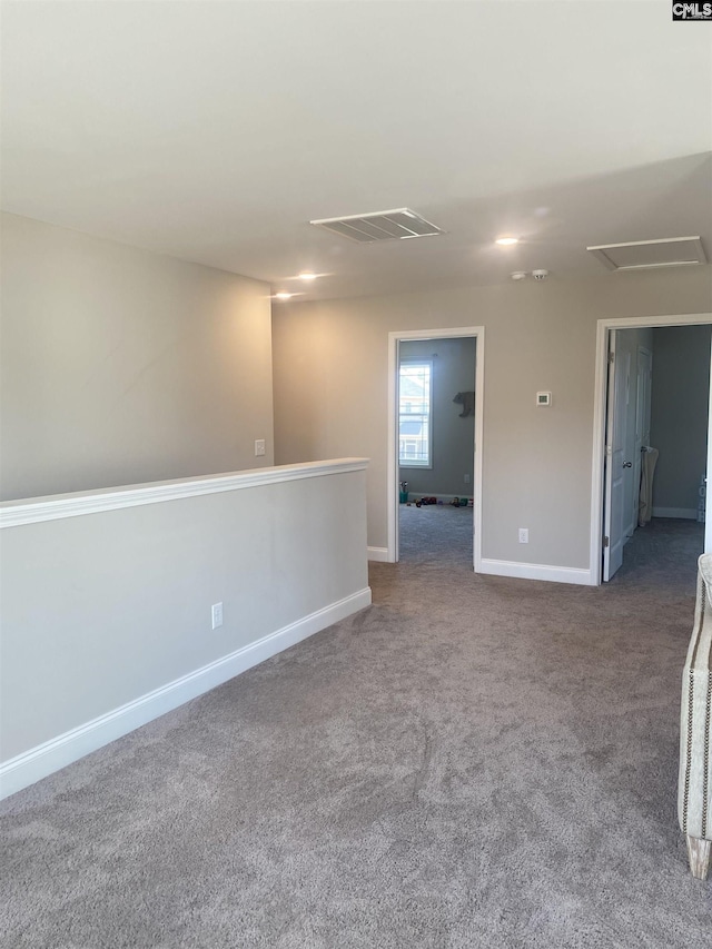 carpeted empty room with visible vents and baseboards