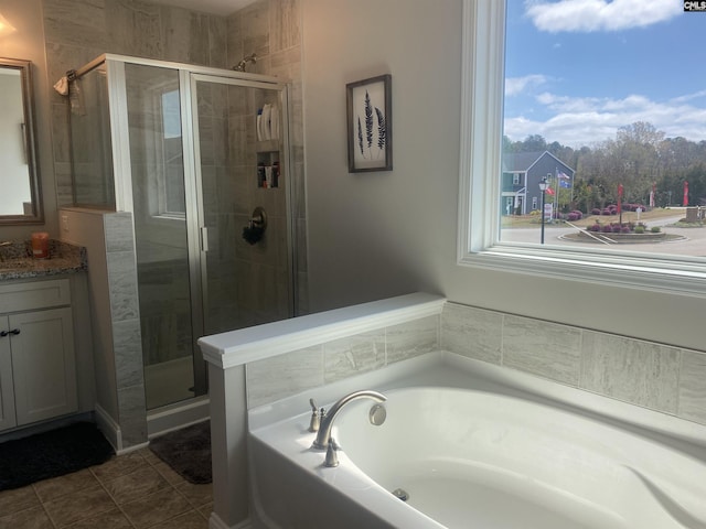 full bathroom featuring tile patterned floors, a stall shower, vanity, and a bath