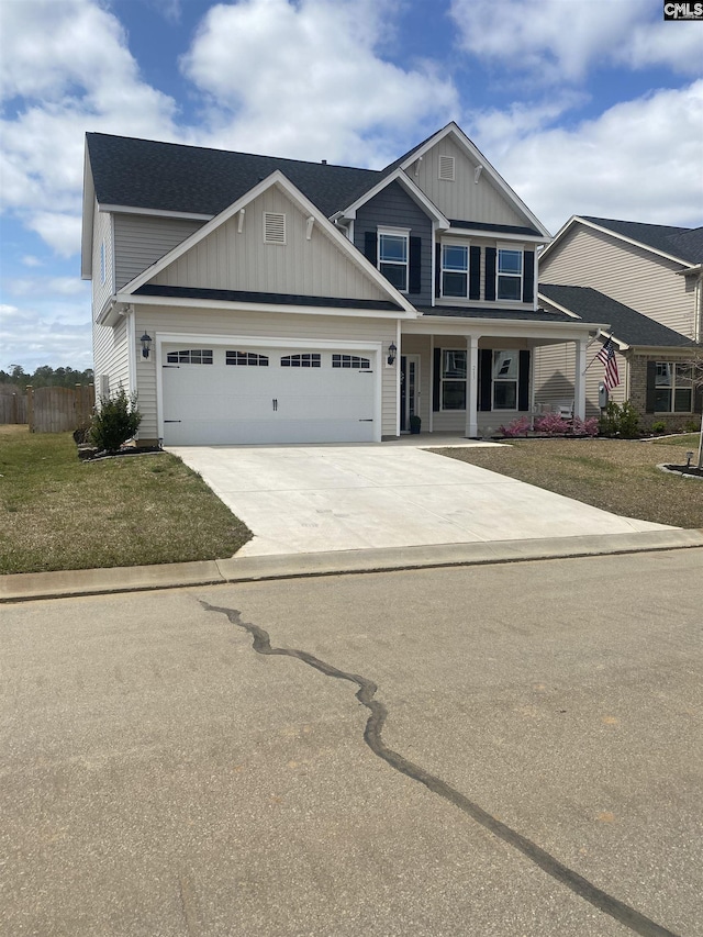 craftsman inspired home with a garage, a front yard, board and batten siding, and driveway