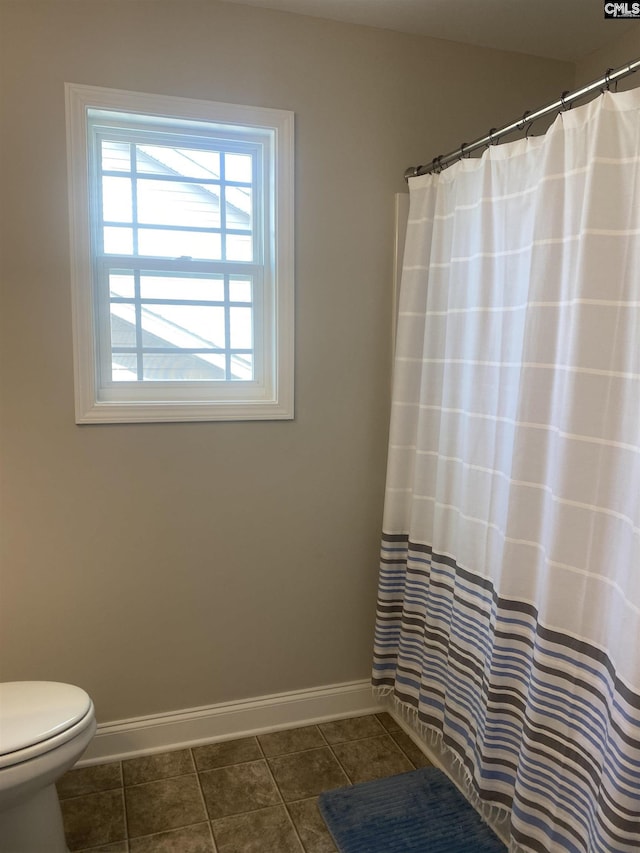 full bathroom with tile patterned flooring, a shower with shower curtain, toilet, and baseboards