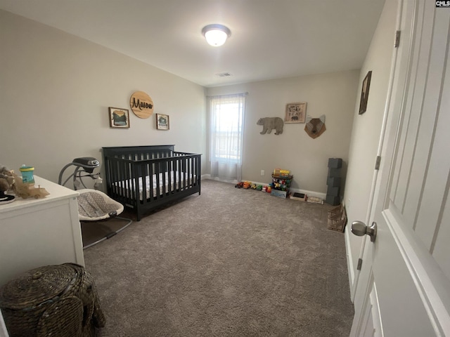 bedroom featuring visible vents, a crib, baseboards, and carpet flooring