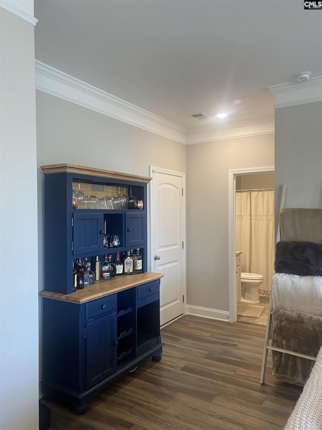 bar featuring visible vents, baseboards, dark wood finished floors, and crown molding