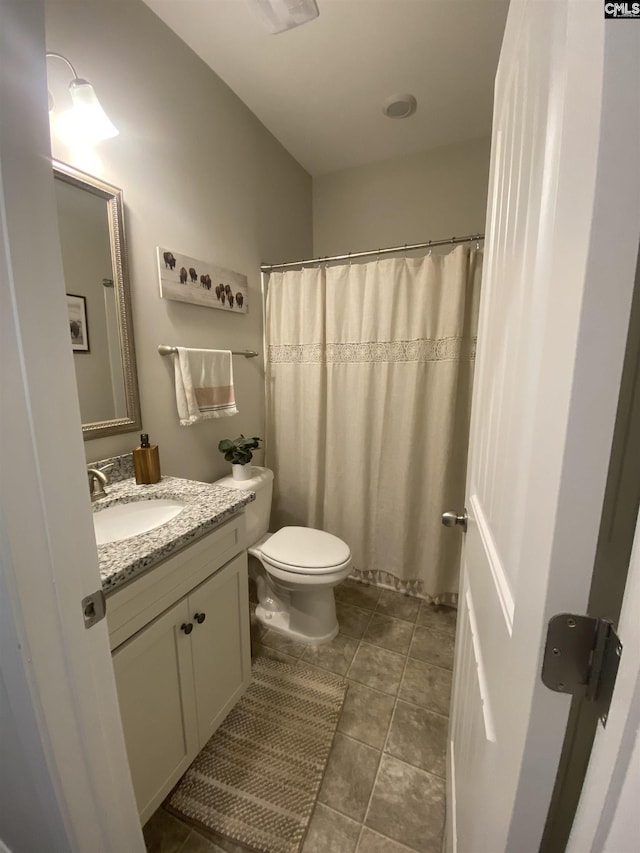 full bathroom with a shower with shower curtain, toilet, vanity, and tile patterned flooring