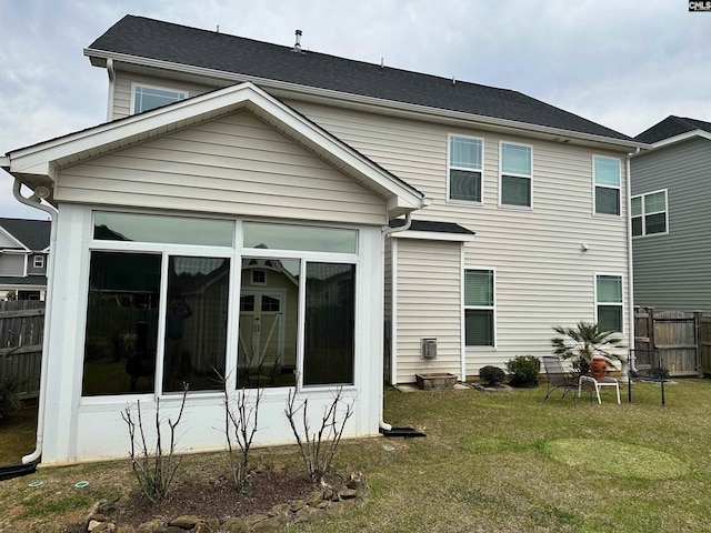 back of property with a yard, fence, and a sunroom