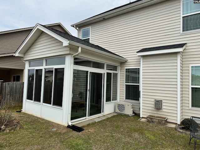 rear view of house featuring ac unit, fence, and a sunroom