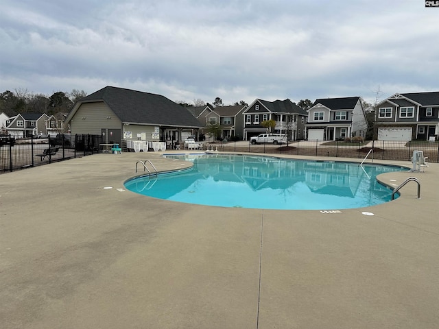 pool featuring a patio, fence, and a residential view