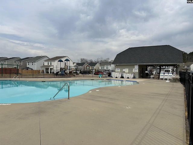 pool featuring a patio area, a residential view, and fence