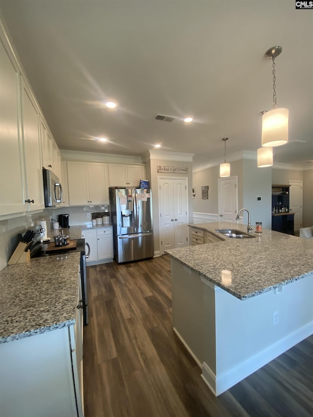 kitchen with crown molding, dark wood finished floors, stainless steel appliances, white cabinetry, and a sink