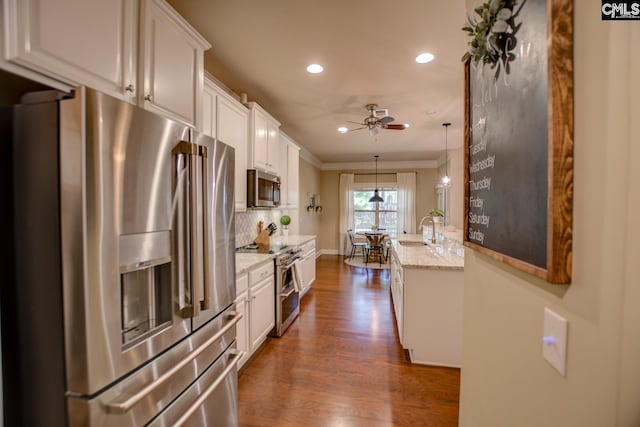 kitchen featuring a ceiling fan, dark wood finished floors, stainless steel appliances, white cabinets, and tasteful backsplash