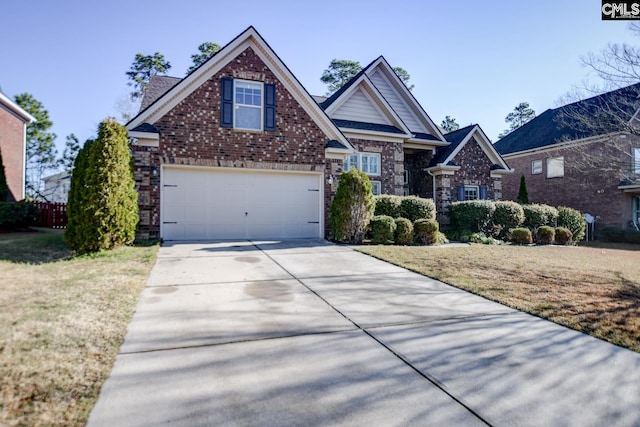 craftsman house with concrete driveway, an attached garage, brick siding, and a front yard