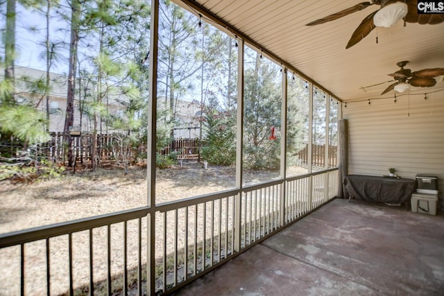 unfurnished sunroom with ceiling fan