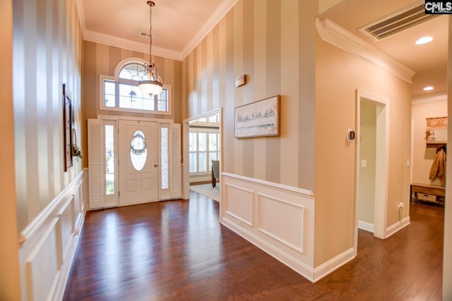 foyer entrance with visible vents, a wainscoted wall, crown molding, and wallpapered walls