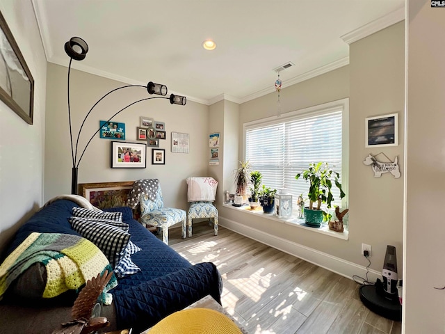 living room with baseboards, wood finished floors, visible vents, and ornamental molding