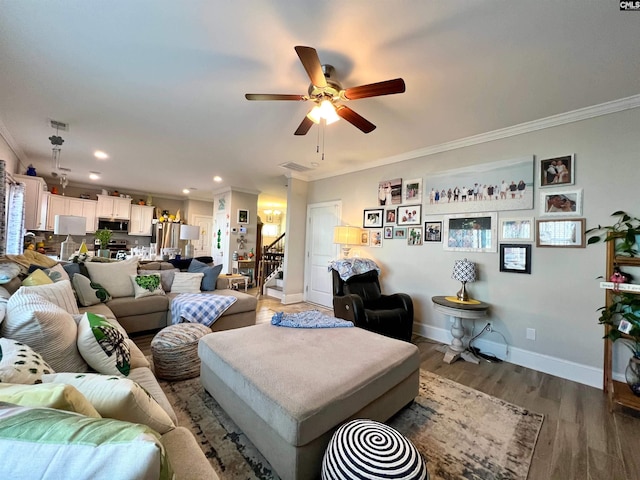 living room with crown molding, wood finished floors, baseboards, and ceiling fan