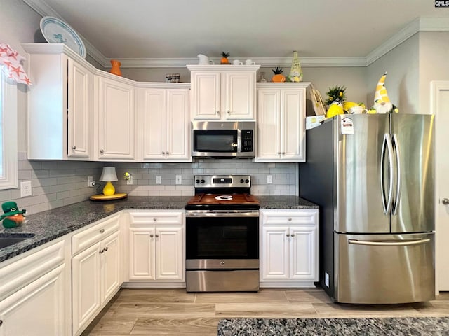 kitchen with light wood-style flooring, appliances with stainless steel finishes, white cabinets, and crown molding