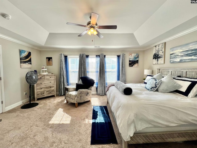 carpeted bedroom with a ceiling fan, a raised ceiling, baseboards, and ornamental molding