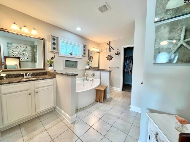 bathroom featuring vanity, tile patterned floors, a bath, and visible vents