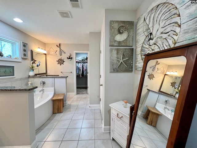 full bath featuring tile patterned flooring, visible vents, a spacious closet, and a bath