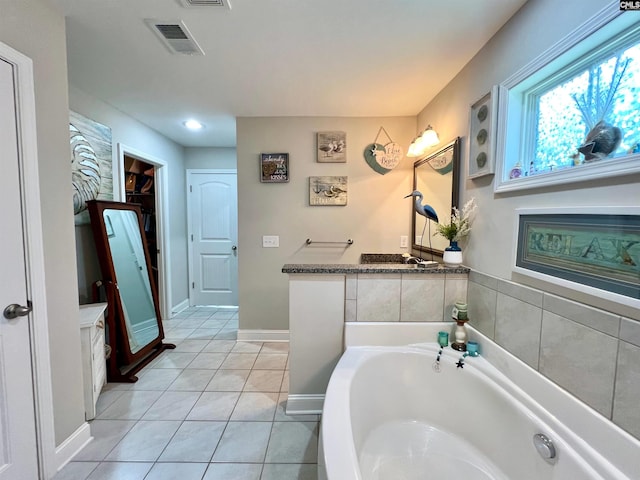 full bathroom with vanity, baseboards, visible vents, tile patterned flooring, and a garden tub