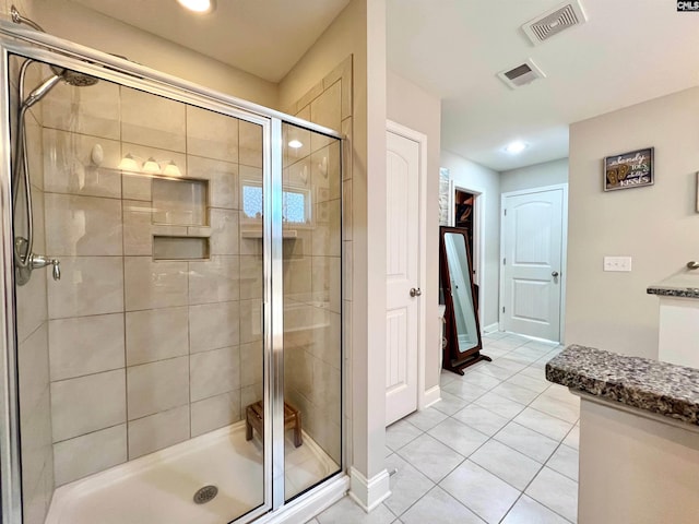 full bathroom with tile patterned floors, visible vents, baseboards, and a shower stall