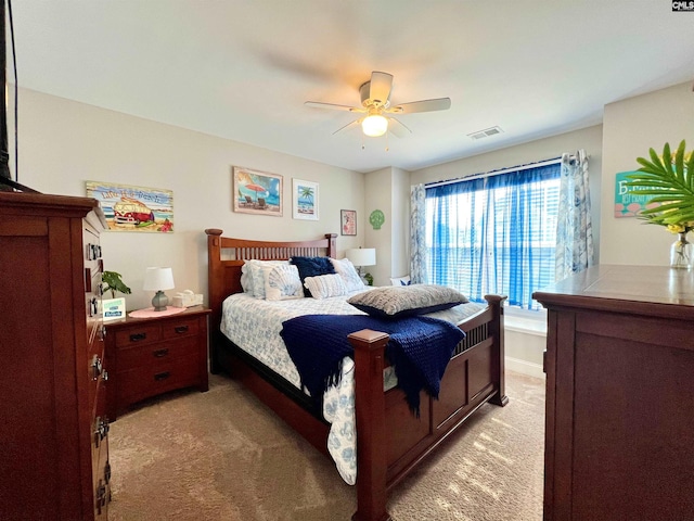 bedroom featuring a ceiling fan, light colored carpet, and visible vents