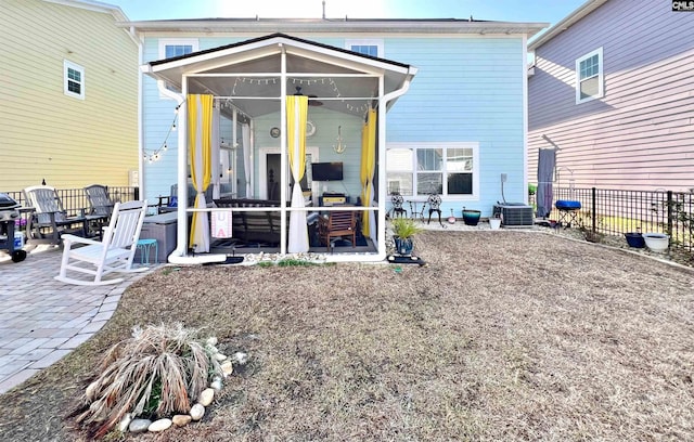 back of house featuring fence, a patio, and a sunroom