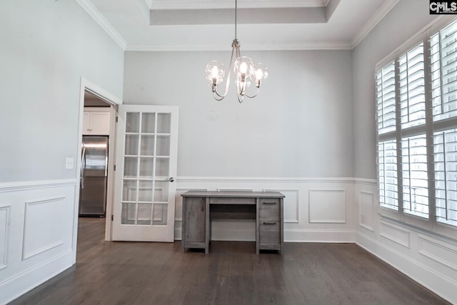 unfurnished dining area featuring a raised ceiling, a notable chandelier, dark wood-style flooring, and crown molding