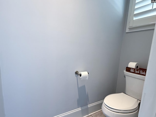 bathroom with toilet and baseboards