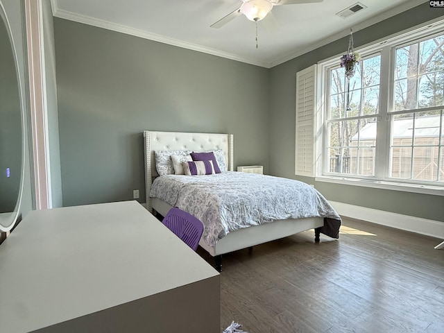 bedroom with dark wood finished floors, visible vents, multiple windows, and ornamental molding