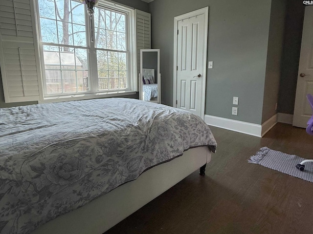 bedroom with baseboards and dark wood-style flooring