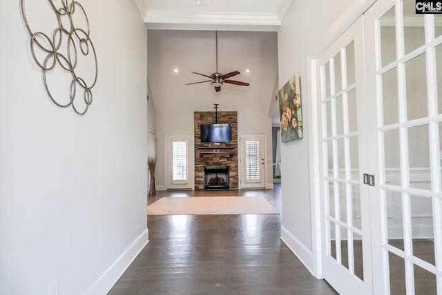 unfurnished living room featuring a fireplace, dark wood-style floors, baseboards, and ornamental molding